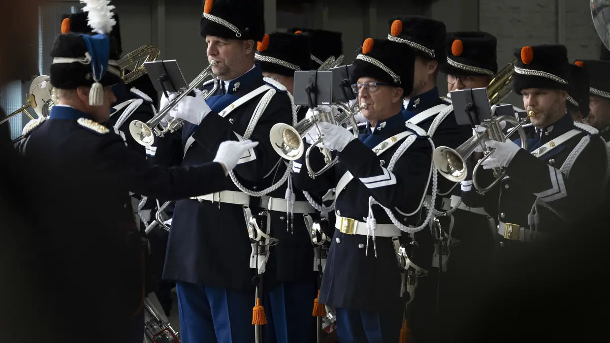 Het orkest Koninklijke Marechaussee speelt op de ceremonie, aangevoerd door de dirigent.