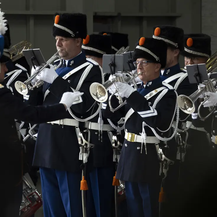 Het orkest Koninklijke Marechaussee speelt op de ceremonie, aangevoerd door de dirigent.