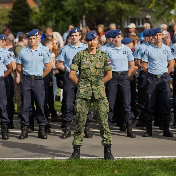 Een groene marechaussee staat voor een groep blauwe collega’s.