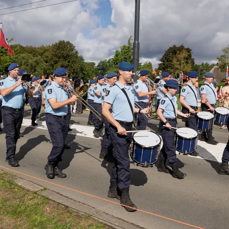 Muzikanten van de Marechaussee marcheren voorwaarts.