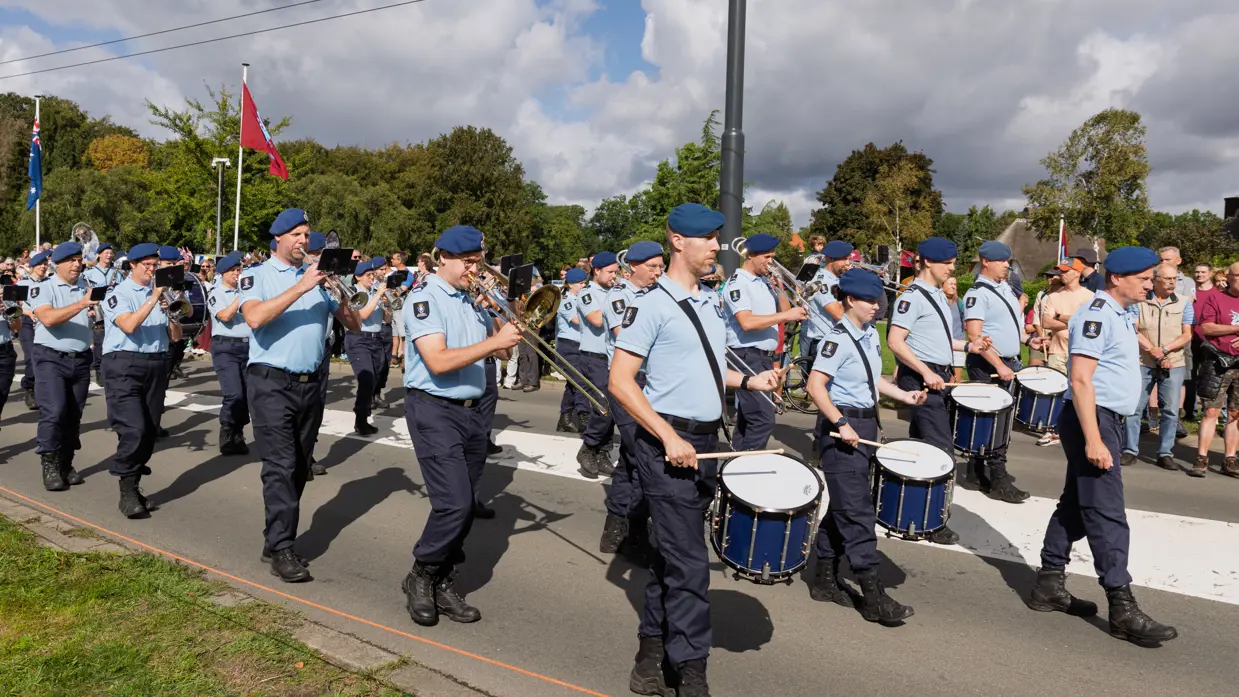 Muzikanten van de Marechaussee marcheren voorwaarts.