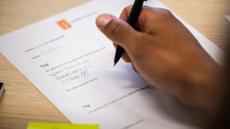 Een instructeur maakt notities op een formulier.