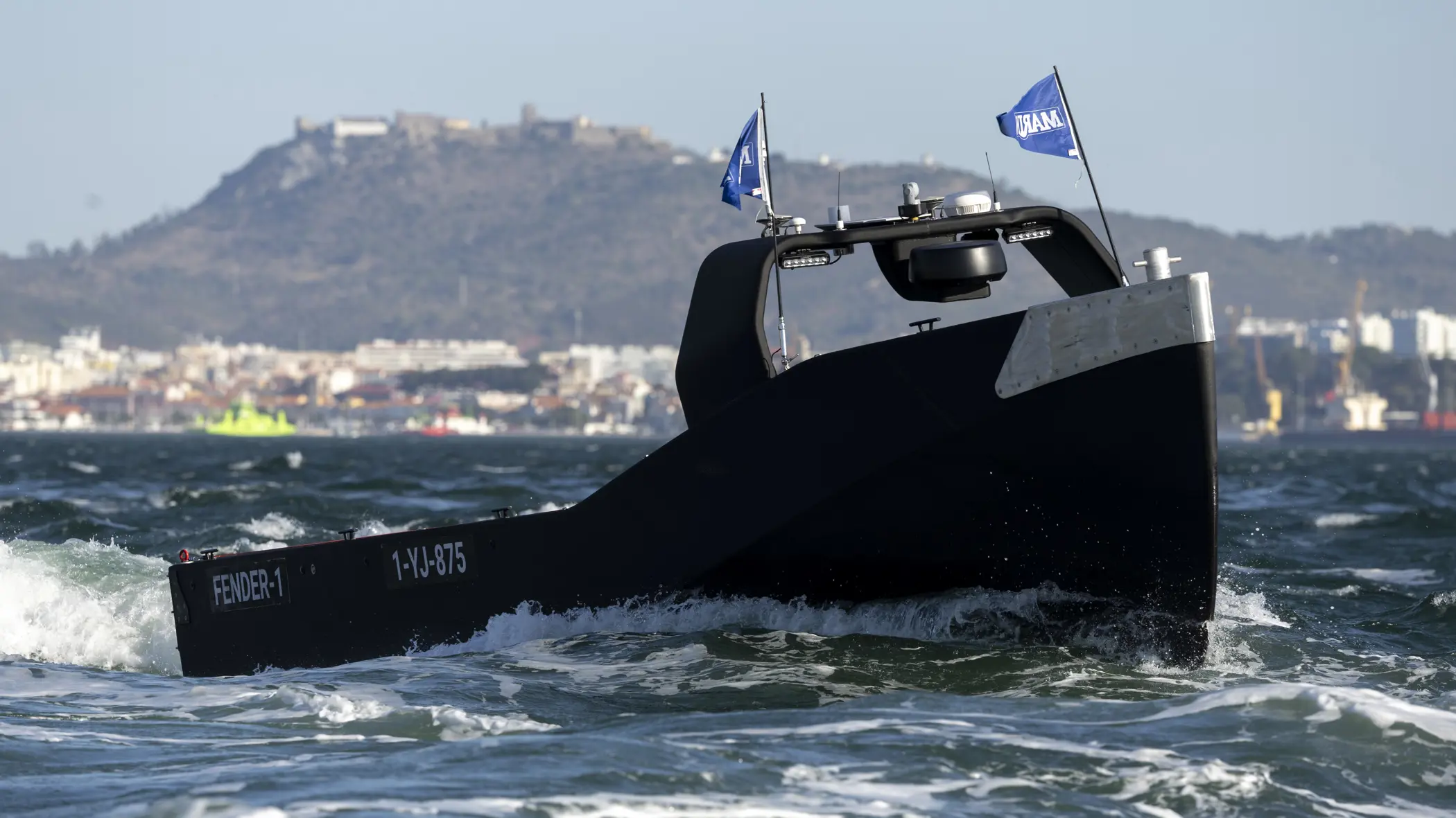 Een zwart, onbemand bootje scheurt over het water.