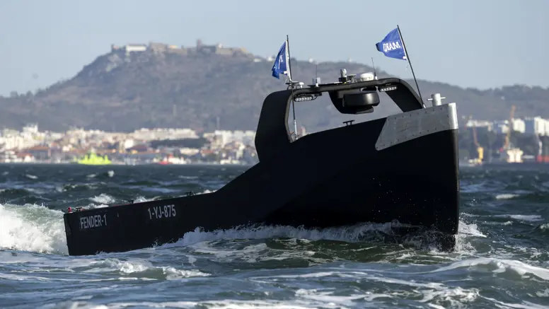 Een zwart, onbemand bootje scheurt over het water.