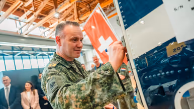 Een militair zet zijn handtekening op de romp van de eerste Nederlandse PC-7 MKX.