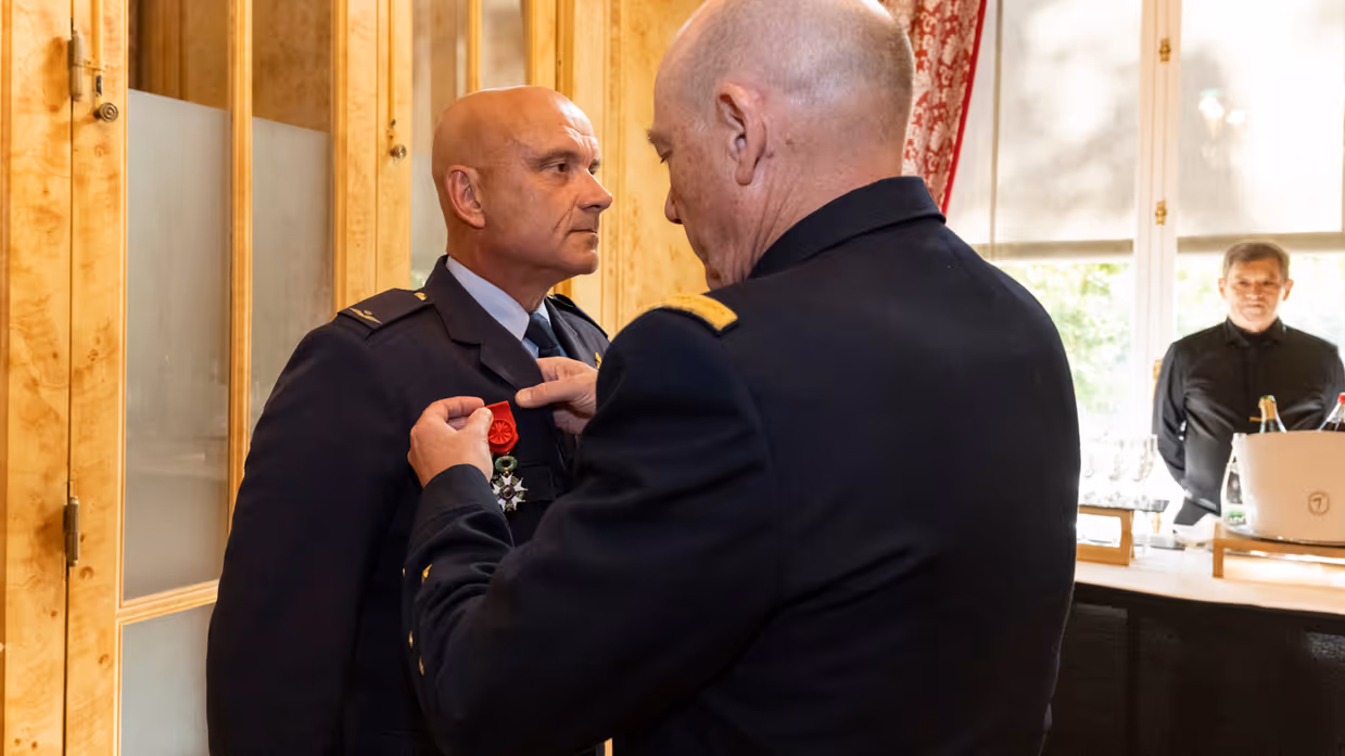 Militair krijgt een onderscheiding omgehangen.
