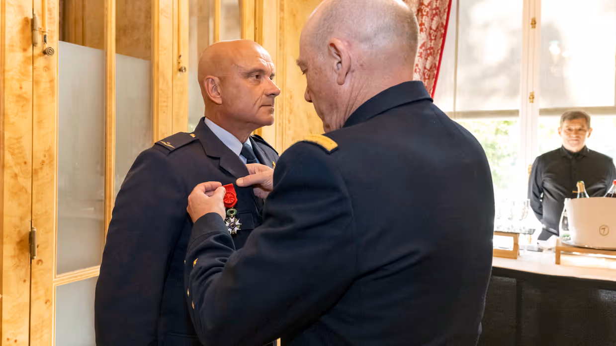 Een militair spelt een medaille op de borst van Steur.