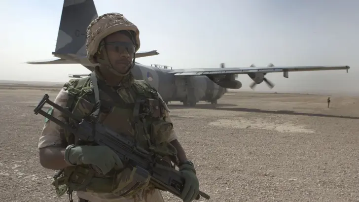 Militairen in verdedigende positie na landing C-130 Hercules op airstrip Tarin Kowt.