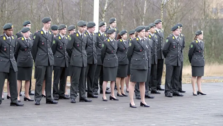 Groep militairen in houding bij beëdiging.