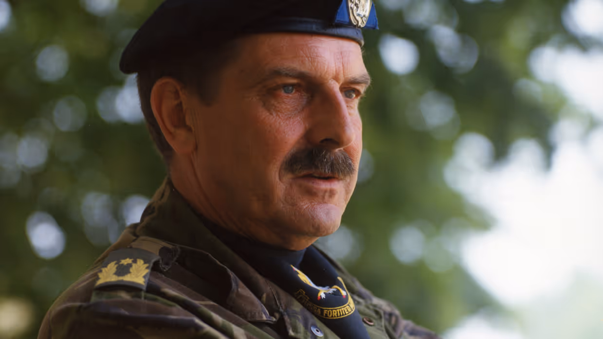 Een militair met snor en zwarte baret in uniform.