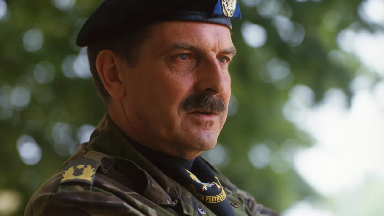 Een militair met snor en zwarte baret in uniform.