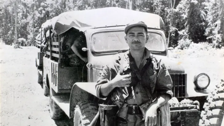 Zwart-wit foto van militair voor een truck.