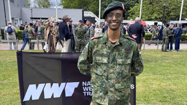 Een militair staat op een grasveld. 