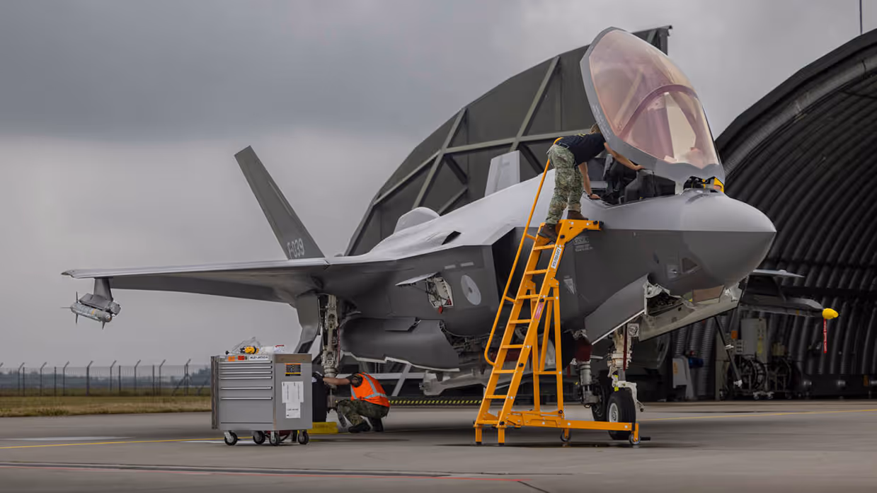 Militair staat op ladder tegen cockpit F-35.