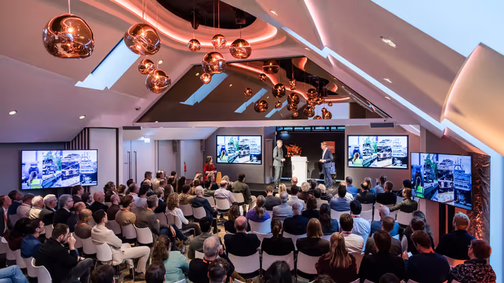 De toehoorders in de zaal, van boven gezien. 