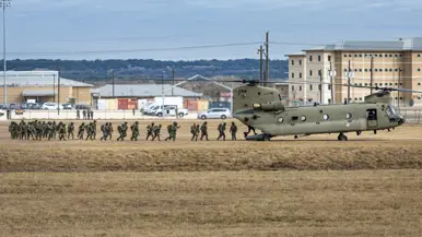 Militairen lopen via de achterklep een Chinook binnen.