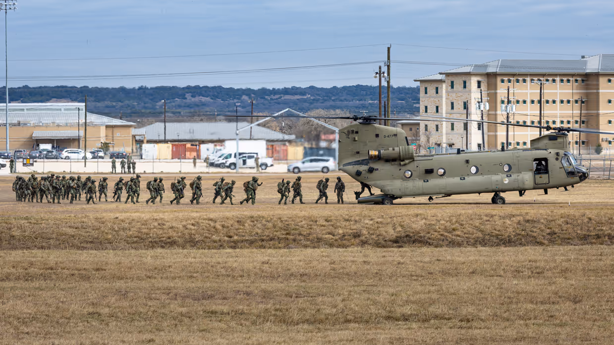 Militairen lopen via de achterklep een Chinook binnen.