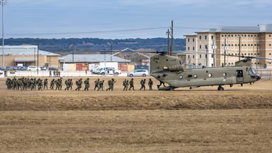 Militairen lopen via de achterklep een Chinook binnen.