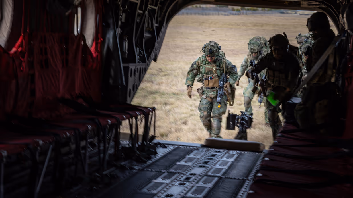 Militairen lopen via ramp Chinook het toestel in. 