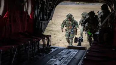 Militairen lopen via ramp Chinook het toestel in. 