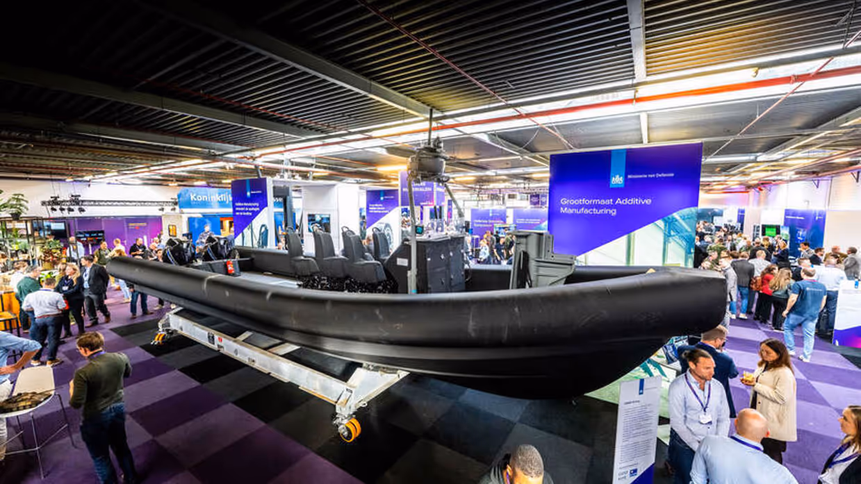 Een 3-D geprint schip op een verhoging op de beursvloer.