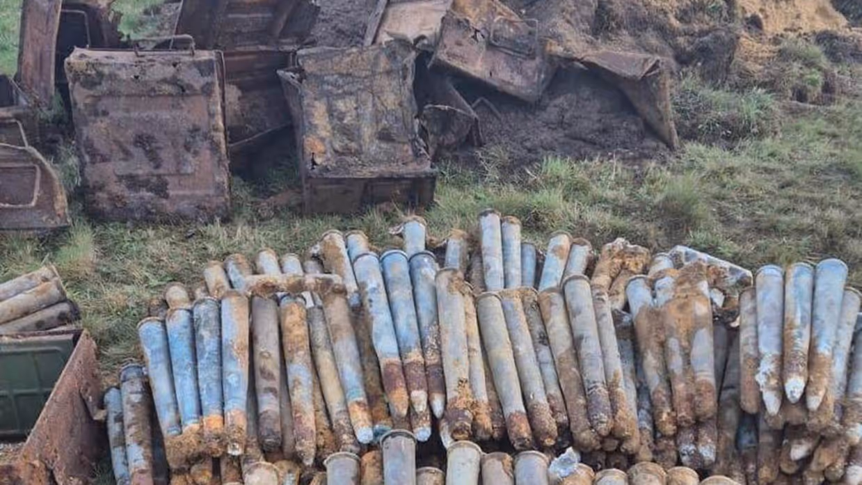 Grote stapels munitie met een berg zand op de achtergrond.