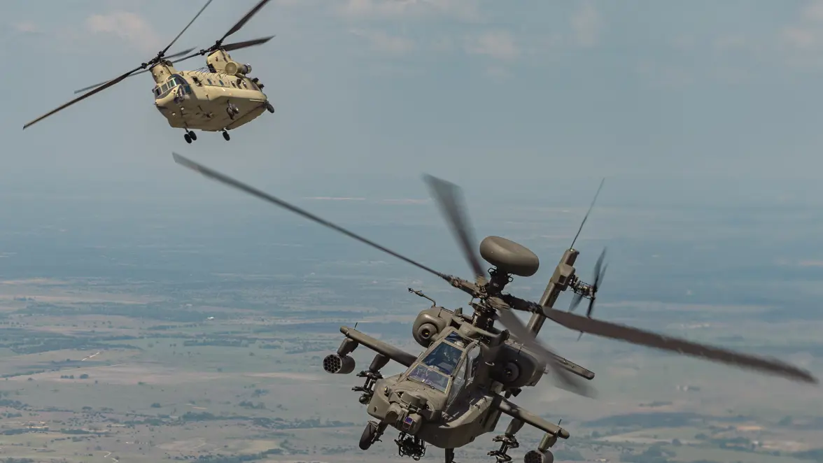 Een Chinook en Apache vliegend over Texaans landschap. 