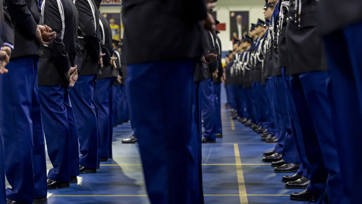 Marechaussees in ceremonieel tenue staan in de houding.