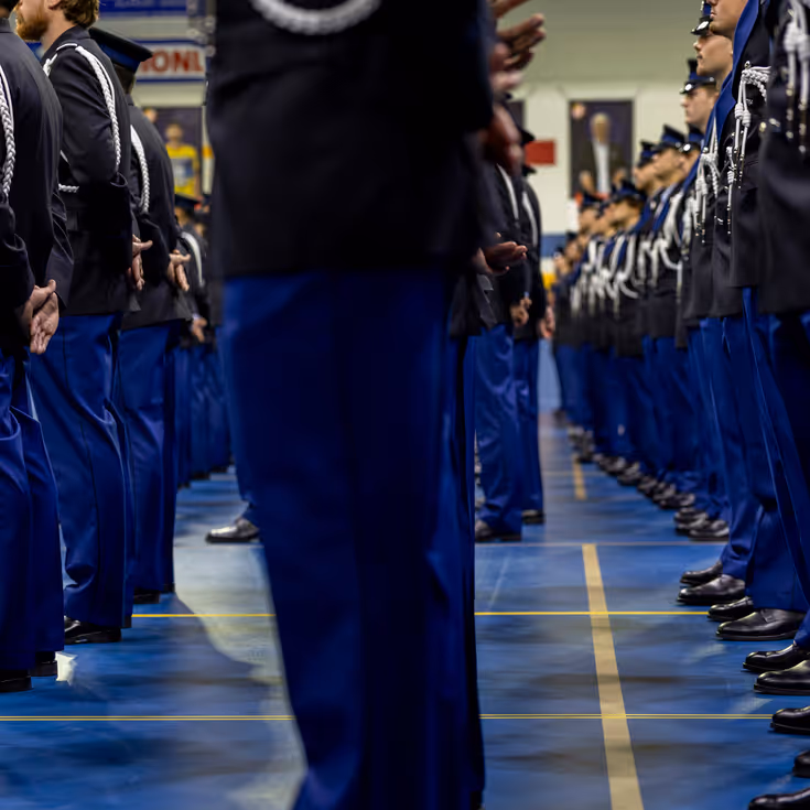 Marechaussees in ceremonieel tenue staan in de houding.