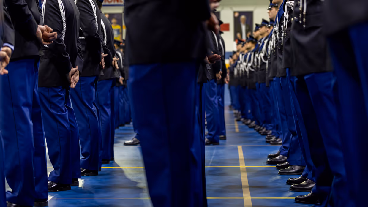 Marechaussees in ceremonieel tenue staan in de houding.