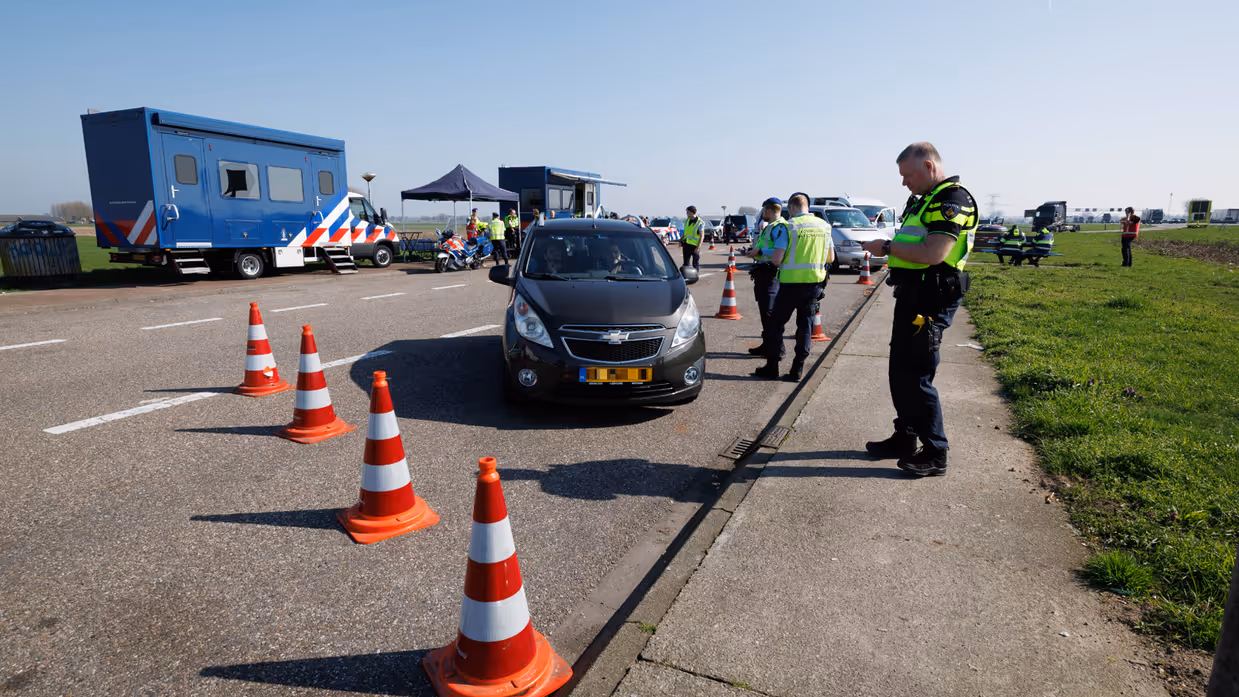 Politie en Marechaussee tijdens een controle op een parkeerplaats.