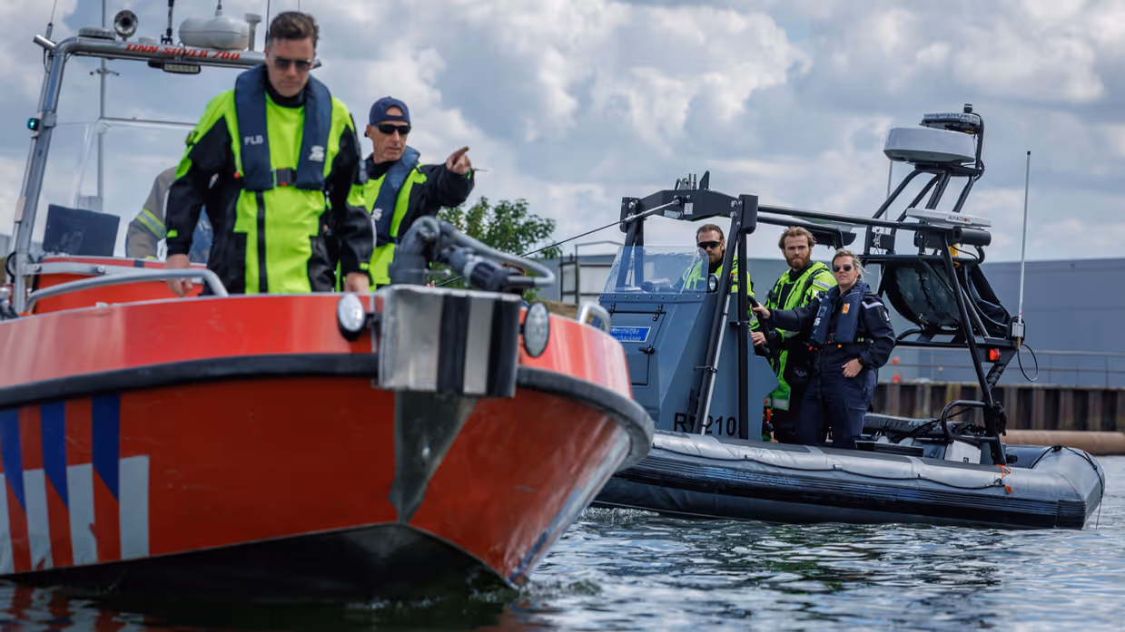 Vaartuig van de brandweer met op de achtergrond een vaartuig van de Marechaussee.