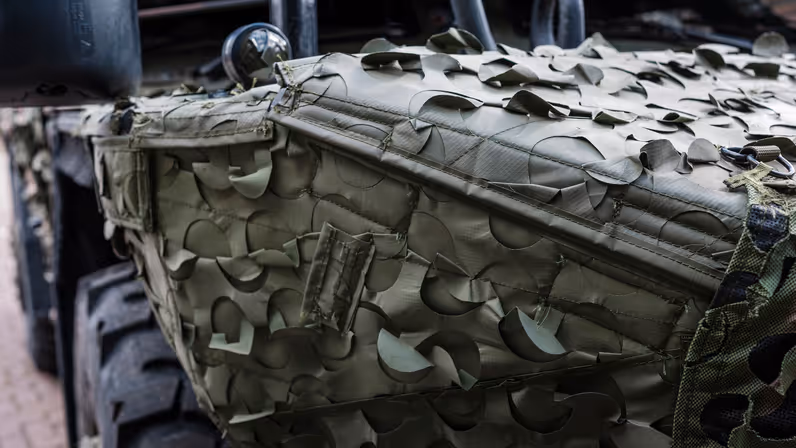 Een militair voertuig met daarop een camouflagesysteem.