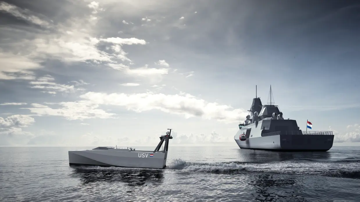 Een klein schip vaart weg van een groot grijs schip op een kalme zee.