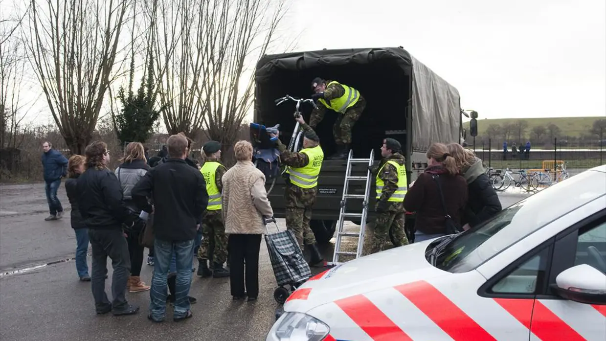 Reservisten werken samen met de politie bij de evacuatie van bewoners.