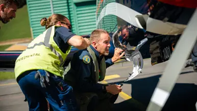 Twee piloten en ondersteunend personeel kijken naar het toestel.