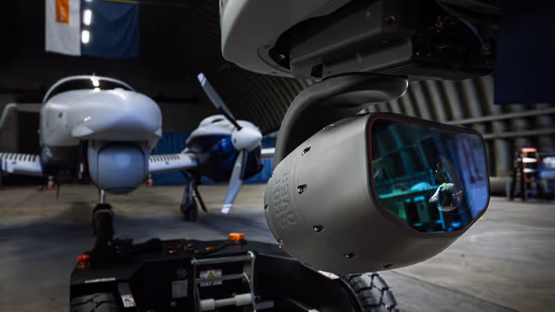 Gestabiliseerd camerasysteem onder de neus van het KMar-patrouillevliegtuig in de hangaar op vliegbasis Gilze-Rijen. 