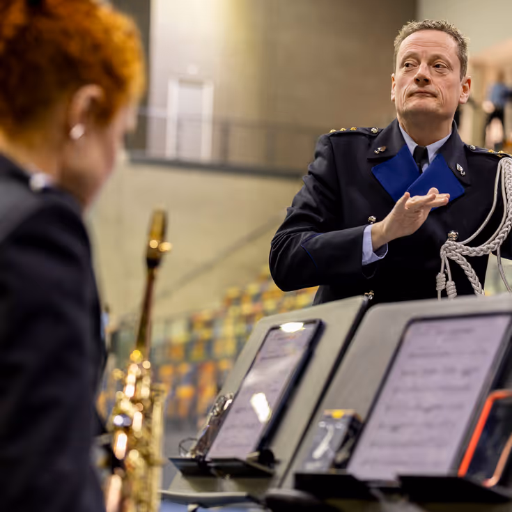 Dirigent van het KMar-orkest, Ido Gerard Kempenaar, in actie tijdens de beëdiging van het OTCKMar in een sporthal in Apeldoorn.