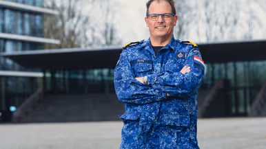Portretten van Paul Flos in blauw gevechtspak van de marine en Carine van Bentum met een hand in haar zij. 