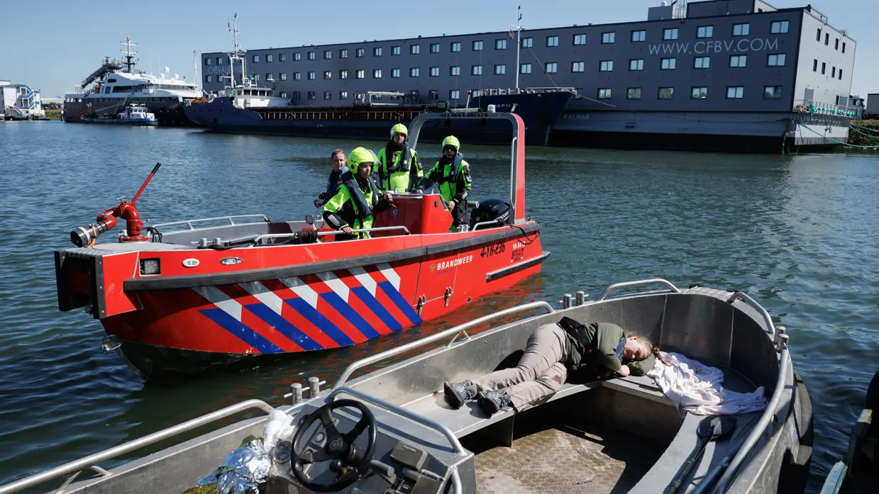Vaartuig met een lotusslachtoffer met op de achtergrond een vaartuig van de Marechaussee.