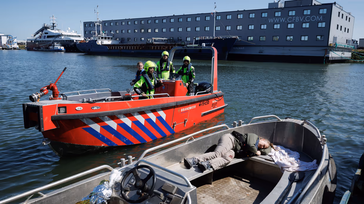 Vaartuig met een lotusslachtoffer met op de achtergrond een vaartuig van de Marechaussee.