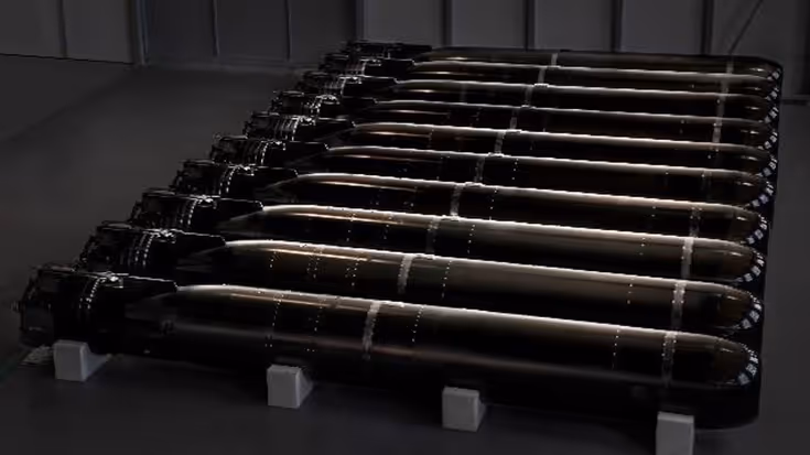 Een rijtje torpedo’s liggend in een bak.
