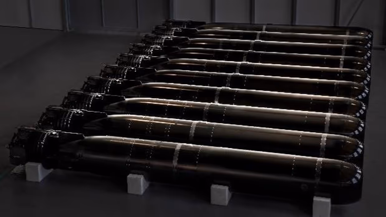 Een rijtje torpedo’s liggend in een bak.