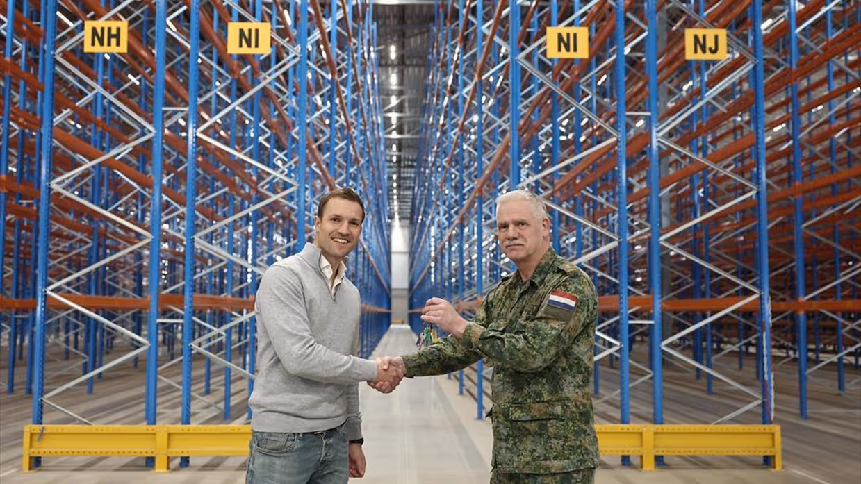 De verhuurder overhandigt de sleutel aan kolonel Jan Vonk. 