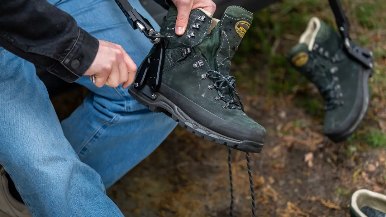 Links: iemand trekt een groene bergschoen aan met een zwarte beugel, buiten op een bosbodem met bladeren.    Midden: Iemand in camouflagebroek zit op een auto met bruine sokken en houdt een groene bergschoen vast.    Rechts: Een man in uniform houdt een metertje vast. 