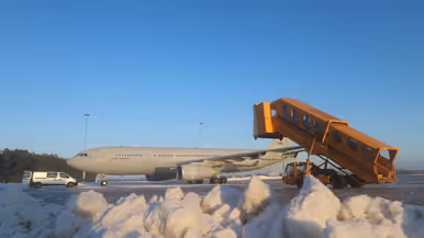 Links: drie gele sneeuwruimvoertuigen werken op een besneeuwde startbaan van een luchthaven, met een grijze lucht en sneeuw aan weerszijden. Rechts: Een Airbus 330MRTT staat op de besneeuwde luchthaven, met een oranje trap die naar de deur rijdt en sneeuwhopen op de voorgrond.