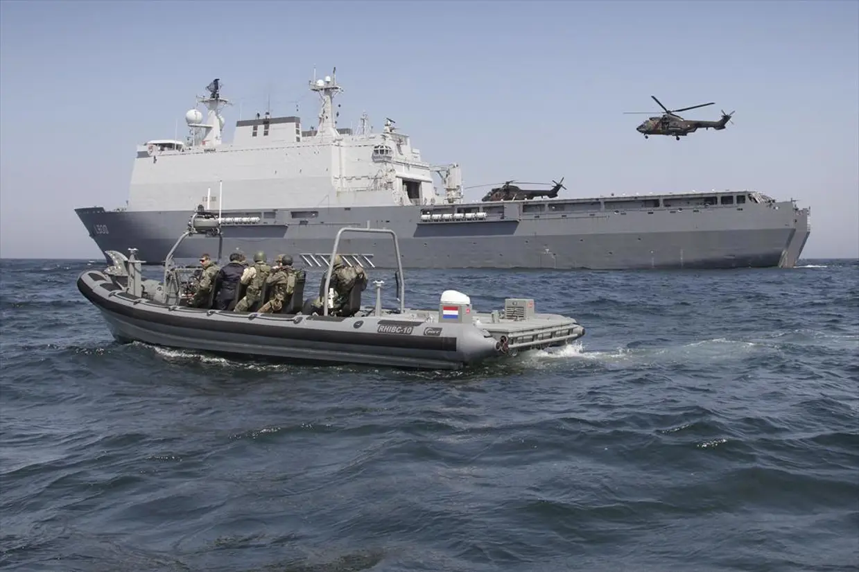 De Frisc naast Zr.Ms. Rotterdam. Op en boven het dek van het schip zijn 2 helikopters te zien.