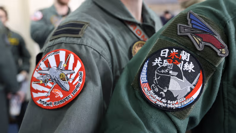 Logo van de oefening op de mouwen van een Nederlandse en Japanse vlieger.