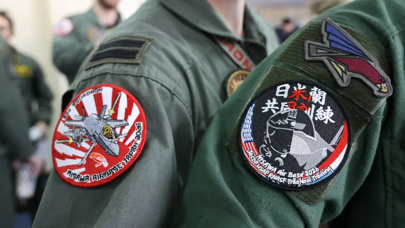 Logo van de oefening op de mouwen van een Nederlandse en Japanse vlieger.
