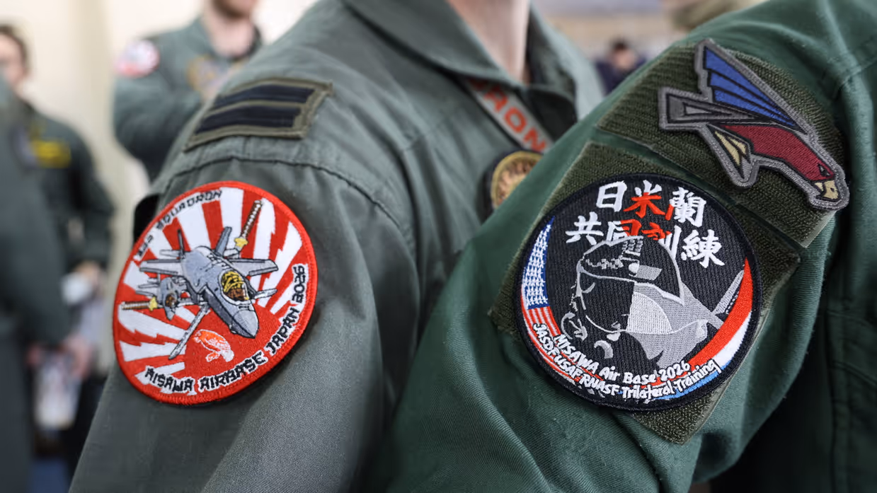 Logo van de oefening op de mouwen van een Nederlandse en Japanse vlieger.